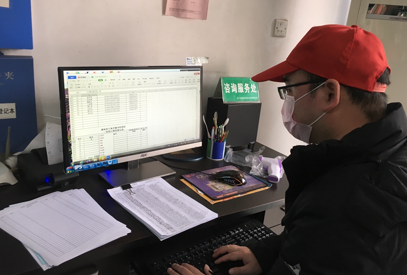 王建對(duì)領(lǐng)取口罩的人員核對(duì)信息、錄入信息